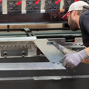 A man fabricating sheet metal used in manufacturing custom switchgear