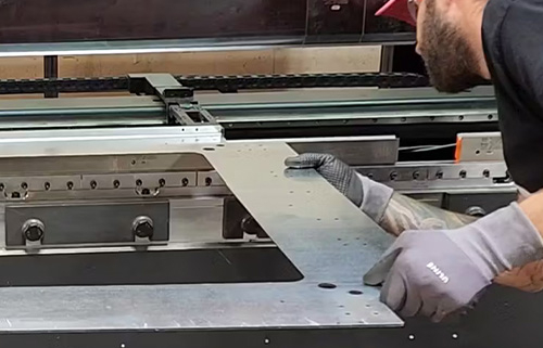 A man fabricating sheet metal used in manufacturing custom switchgear